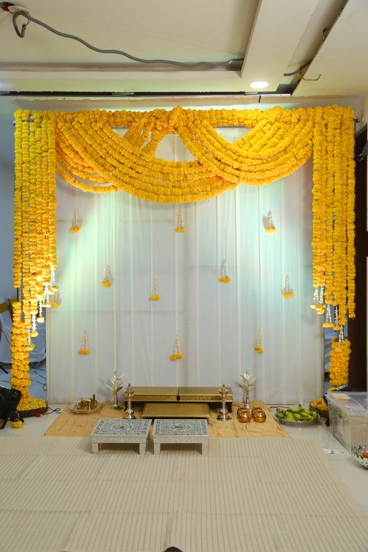 Traditional Pooja Decoration With Marigold Floral Garlands And White Backdrop - balloon and flower decoration by ARV Decor