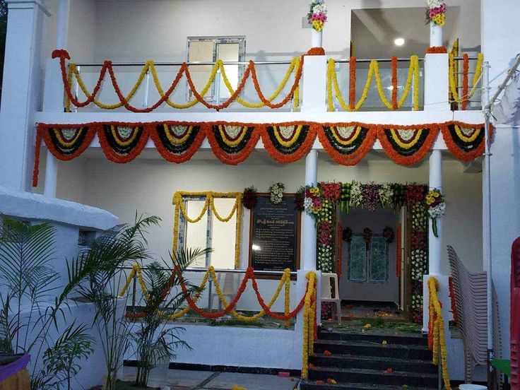 Traditional Housewarming Floral Decor With Orange And Yellow Garlands - balloon and flower decoration by ARV Decor