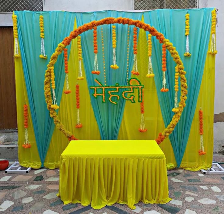 Traditional Mehndi Event Decor In Yellow And Turquoise With Floral Ring Backdrop - wedding decoration by ARV Decor thumbnail 2